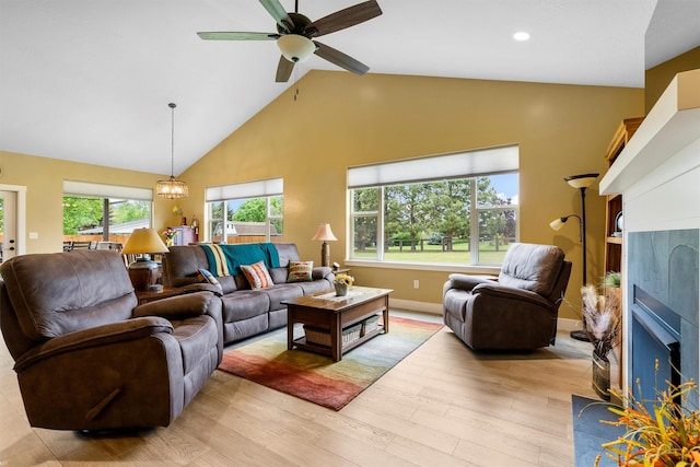 500 Bass Ln, Corvallis, MT 59828 - living room featuring a fireplace, high vaulted ceiling, light wood-style flooring, a ceiling fan, and baseboards