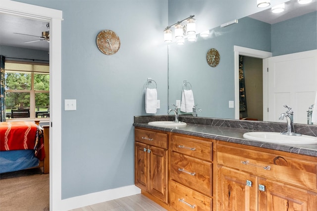 500 Bass Ln, Corvallis, MT 59828 - bathroom featuring a ceiling fan, connected bathroom, double vanity, and baseboards
