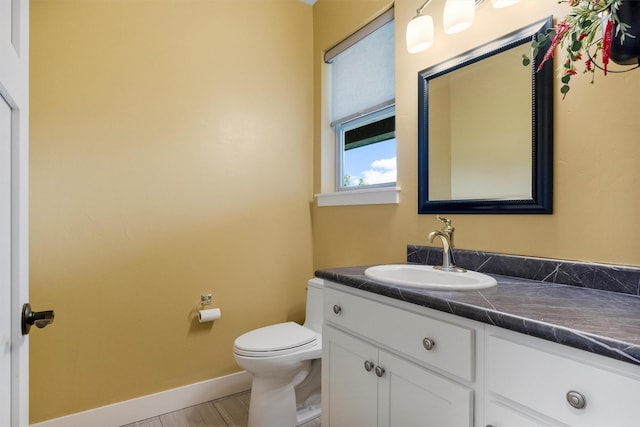500 Bass Ln, Corvallis, MT 59828 - bathroom with toilet, vanity, and baseboards