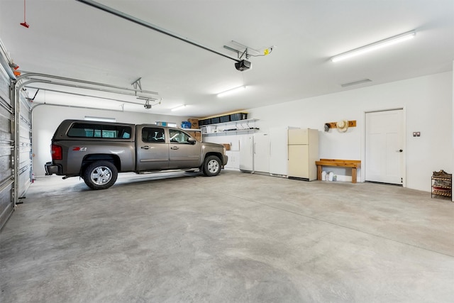 500 Bass Ln, Corvallis, MT 59828 - garage featuring a garage door opener and freestanding refrigerator