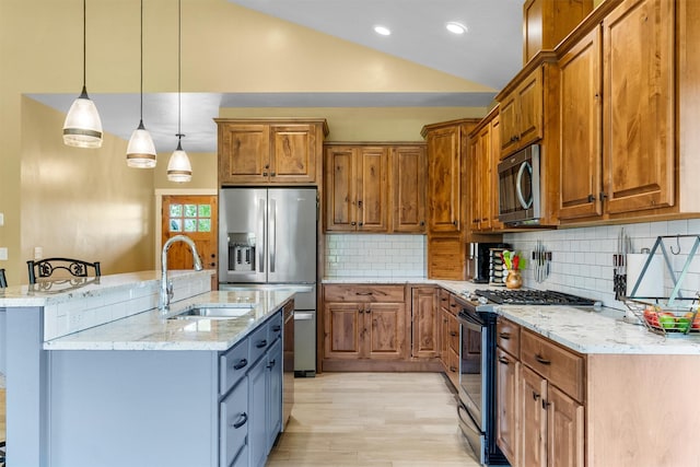 500 Bass Ln, Corvallis, MT 59828 - kitchen featuring appliances with stainless steel finishes, a sink, brown cabinets, vaulted ceiling, and light wood-style floors