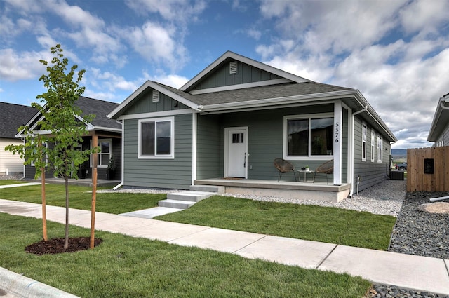 5576 Cattle Dr, Missoula, MT 59808 - view of front of home featuring a porch, board and batten siding, a front yard, and roof with shingles