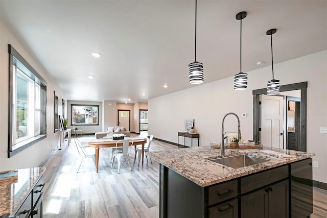 5576 Cattle Dr, Missoula, MT 59808 - kitchen featuring a sink, light wood-type flooring, baseboards, dishwashing machine, and open floor plan