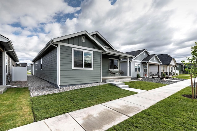 5576 Cattle Dr, Missoula, MT 59808 - view of front of property with board and batten siding, a front yard, and covered porch