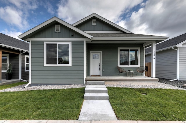 5576 Cattle Dr, Missoula, MT 59808 - bungalow featuring covered porch, a front yard, and board and batten siding