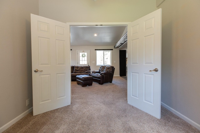 carpeted living area featuring baseboards