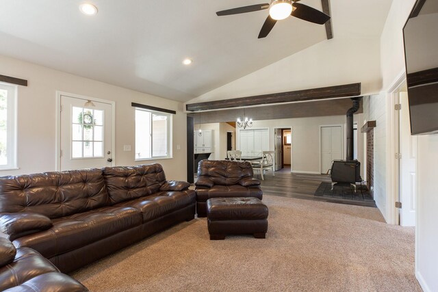 living room with a wood stove, lofted ceiling, a ceiling fan, recessed lighting, and a chandelier
