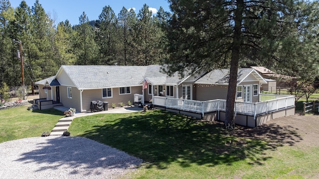 6400 Boondock Ln, Clinton, MT 59825 - back of house featuring a lawn, a wooden deck, and a shingled roof