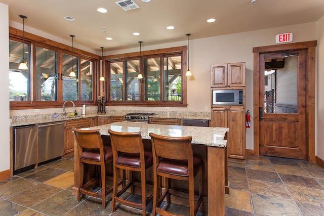 6002 St Moritz Dr Unit A, Whitefish, MT 59937 - kitchen featuring stone tile floors, recessed lighting, stainless steel appliances, a sink, and light stone countertops