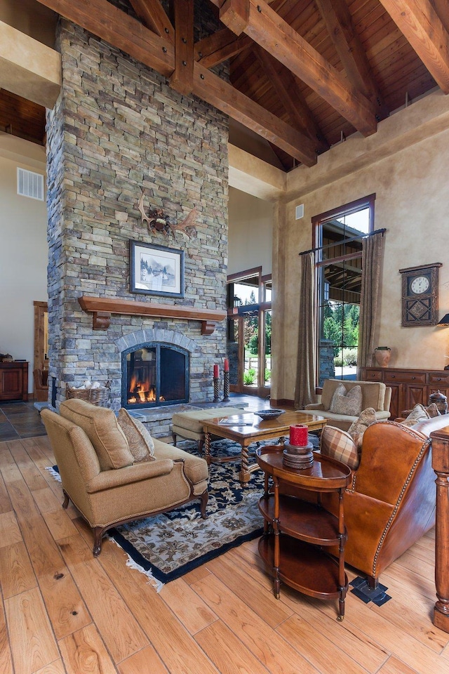 6002 St Moritz Dr Unit A, Whitefish, MT 59937 - living room with a high ceiling, beamed ceiling, wood-type flooring, wooden ceiling, and a stone fireplace
