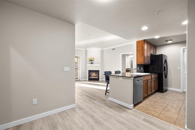 6002 St Moritz Dr Unit A, Whitefish, MT 59937 - kitchen with stainless steel dishwasher, dark countertops, open floor plan, black refrigerator with ice dispenser, and baseboards