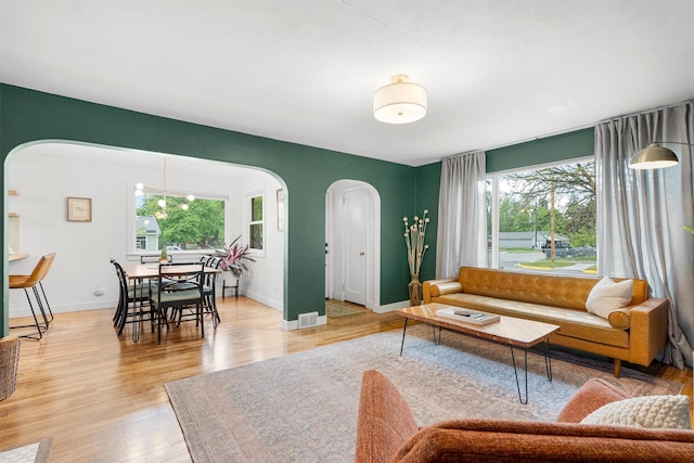 1533 S 10th St W, Missoula, MT 59801 - living area featuring arched walkways, healthy amount of natural light, and light wood-style floors