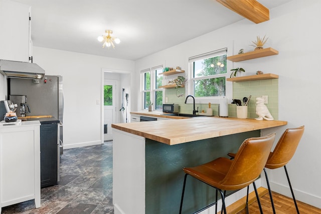 1533 S 10th St W, Missoula, MT 59801 - kitchen featuring butcher block counters, open shelves, backsplash, ventilation hood, and beamed ceiling