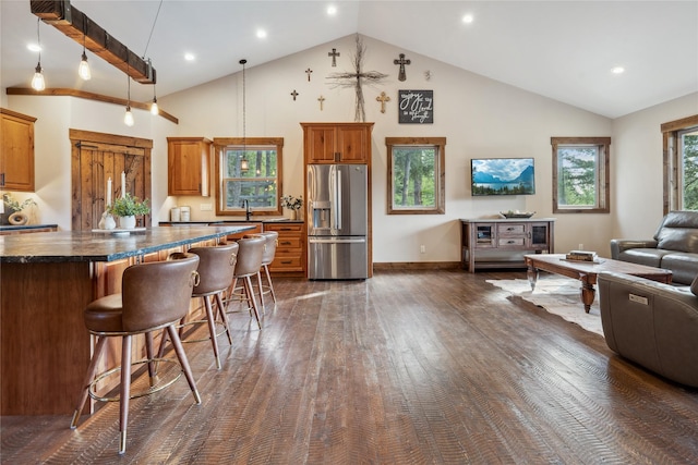 200 Lakeview Ter, Marion, MT 59925 - kitchen with stainless steel fridge with ice dispenser, open floor plan, a breakfast bar area, dark wood-style flooring, and brown cabinets