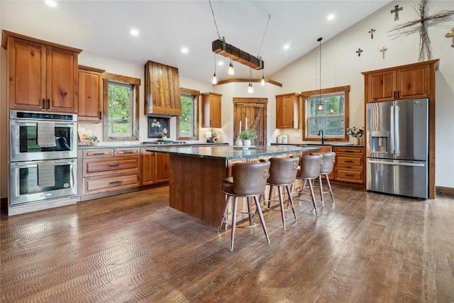 200 Lakeview Ter, Marion, MT 59925 - kitchen with stainless steel appliances, brown cabinets, a center island, a kitchen bar, and high vaulted ceiling