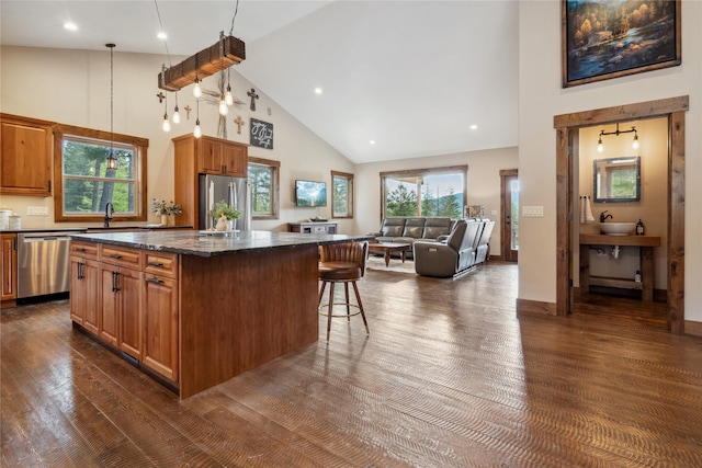 200 Lakeview Ter, Marion, MT 59925 - kitchen featuring stainless steel appliances, high vaulted ceiling, a center island, dark wood-style floors, and a breakfast bar area