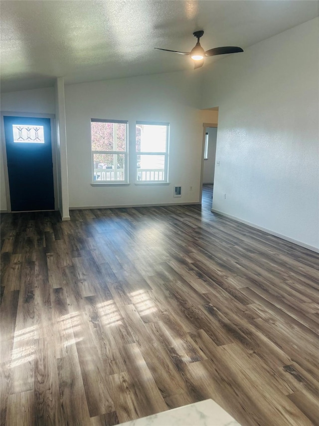 4 Weber Ave, Polson, MT 59860 - unfurnished living room featuring lofted ceiling, dark wood-style flooring, ceiling fan, and a textured ceiling