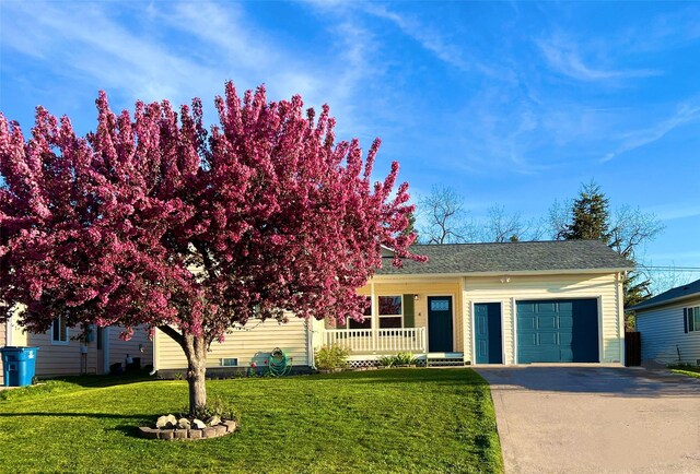 4 Weber Ave, Polson, MT 59860 - view of front of house with covered porch, a garage, concrete driveway, a front yard, and roof with shingles