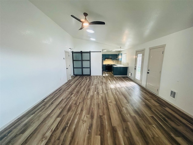 4 Weber Ave, Polson, MT 59860 - unfurnished living room featuring lofted ceiling, dark wood finished floors, a ceiling fan, baseboards, and a barn door