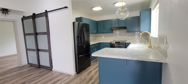 4 Weber Ave, Polson, MT 59860 - kitchen with black fridge with ice dispenser, blue cabinetry, a sink, a peninsula, and light countertops