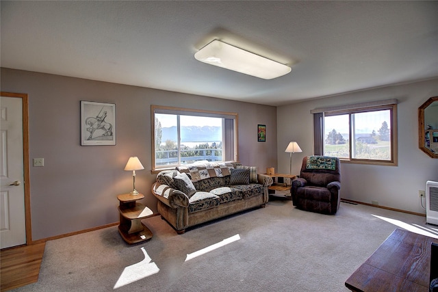 carpeted living area featuring plenty of natural light and baseboards