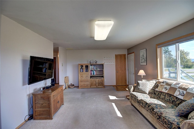 living area featuring light colored carpet and baseboards