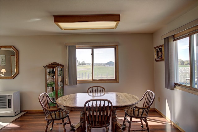 dining area featuring dark wood-style floors, baseboards, and heating unit