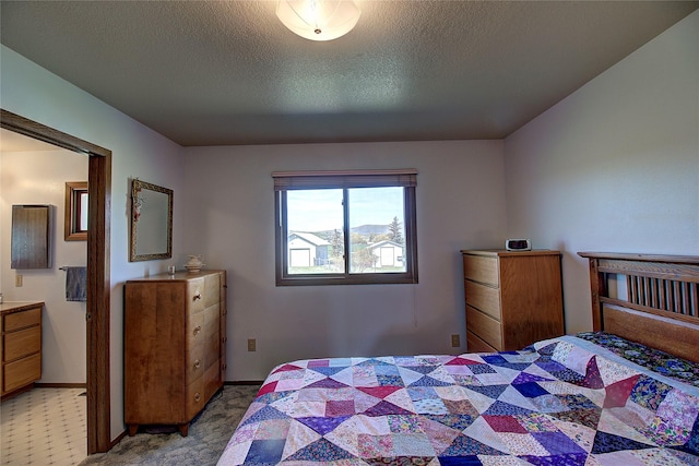 bedroom with a textured ceiling, baseboards, and light carpet