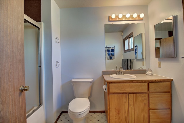 full bath with toilet, tile patterned floors, vanity, baseboards, and enclosed tub / shower combo