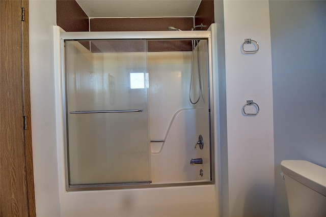 full bath with toilet and bath / shower combo with glass door