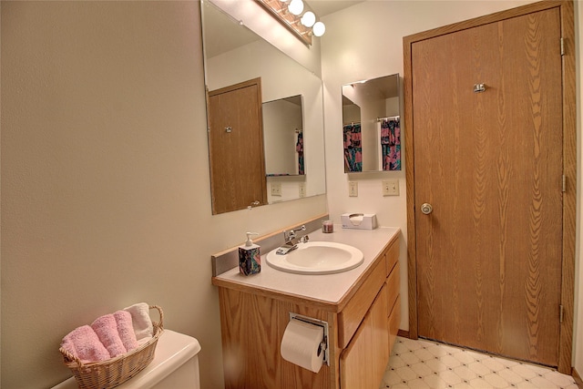 bathroom featuring tile patterned floors, vanity, and toilet