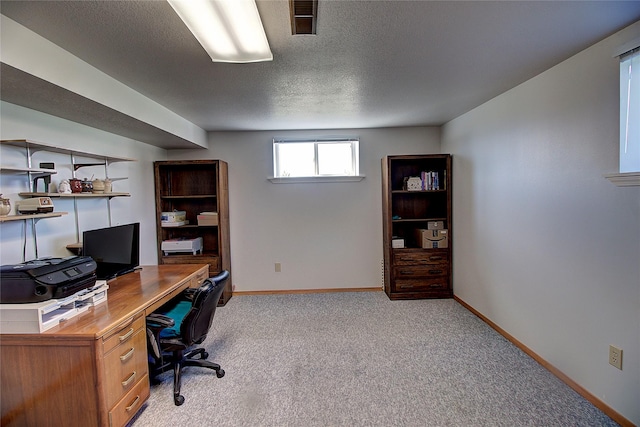office area featuring a textured ceiling, light carpet, and baseboards