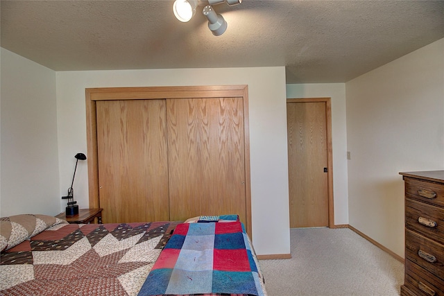 bedroom with carpet flooring, baseboards, and a textured ceiling