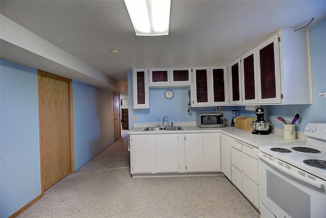 kitchen featuring white range with electric stovetop, stainless steel microwave, a sink, light countertops, and glass insert cabinets
