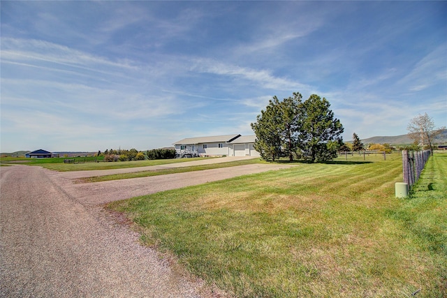 view of front of house with a rural view, a mountain view, and driveway