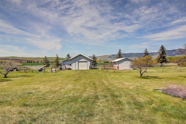 view of yard with an outbuilding, a mountain view, and a view of countryside