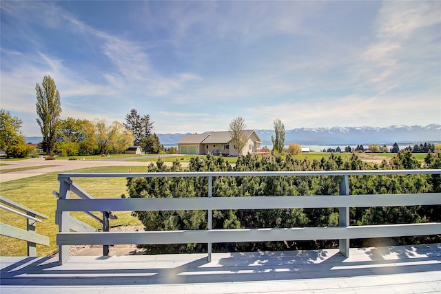 wooden terrace with a mountain view and a yard