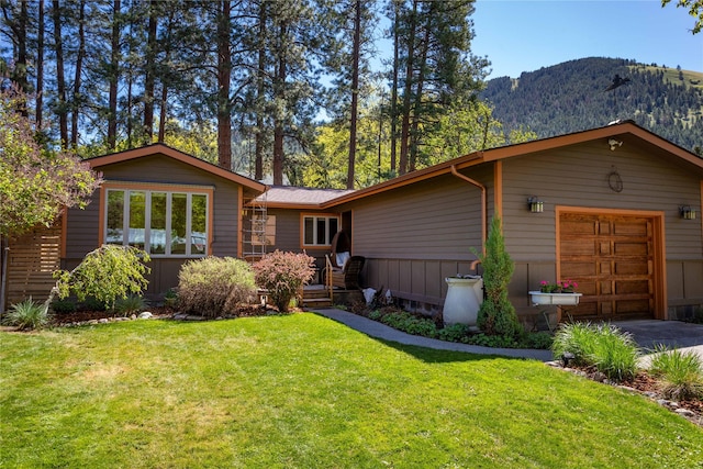 2406 Raymond Ave, Missoula, MT 59802 - view of front facade featuring a mountain view, a front lawn, concrete driveway, and an attached garage