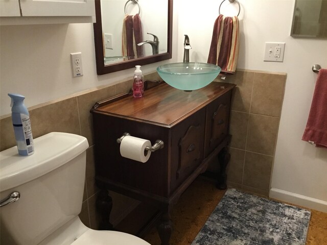 403 S Cherry St, Townsend, MT 59644 - half bath featuring tile walls, toilet, vanity, and a wainscoted wall