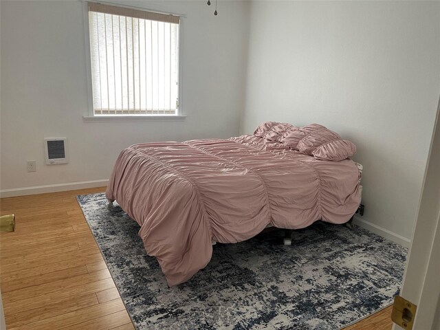 403 S Cherry St, Townsend, MT 59644 - bedroom featuring wood finished floors, baseboards, and heating unit