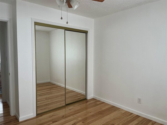 403 S Cherry St, Townsend, MT 59644 - unfurnished bedroom with light wood finished floors, a closet, a textured ceiling, baseboards, and ceiling fan