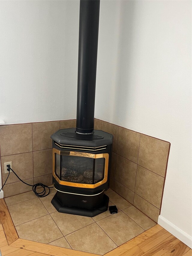 403 S Cherry St, Townsend, MT 59644 - detailed view of a wood stove, tile walls, and wood finished floors