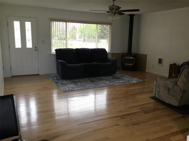 403 S Cherry St, Townsend, MT 59644 - living room with a ceiling fan, light wood-type flooring, and a wood stove
