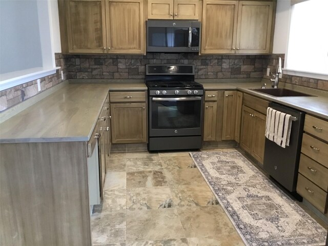 403 S Cherry St, Townsend, MT 59644 - kitchen with stainless steel appliances, a sink, backsplash, stone finish floors, and light countertops