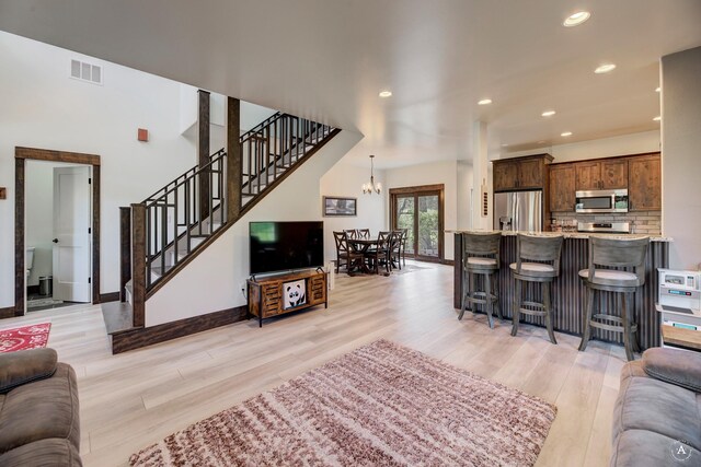 5235 Creekside Ln, Helena, MT 59601 - living room with light wood finished floors, a chandelier, stairs, recessed lighting, and baseboards