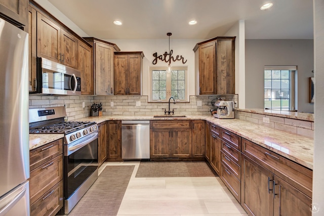 5235 Creekside Ln, Helena, MT 59601 - kitchen with appliances with stainless steel finishes, a sink, tasteful backsplash, light stone countertops, and recessed lighting