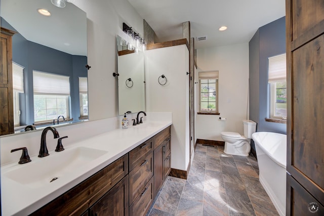 5235 Creekside Ln, Helena, MT 59601 - full bath featuring baseboards, stone tile floors, healthy amount of natural light, double vanity, and recessed lighting