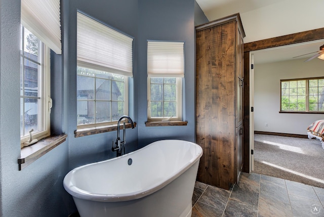 5235 Creekside Ln, Helena, MT 59601 - full bathroom featuring a freestanding tub, a ceiling fan, baseboards, and stone finish floors