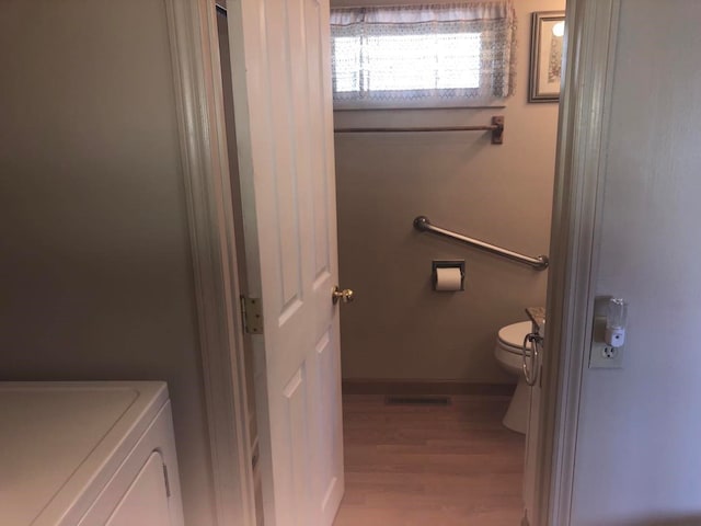 470 Duck Lake Rd, Browning, MT 59417 - bathroom with toilet, wood finished floors, baseboards, and washer / clothes dryer