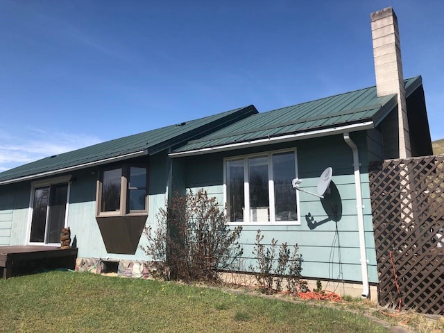 470 Duck Lake Rd, Browning, MT 59417 - view of home's exterior with a chimney, metal roof, and a yard